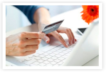 Una persona con in mano la sua carta di credito si appresta ad un acquisto online